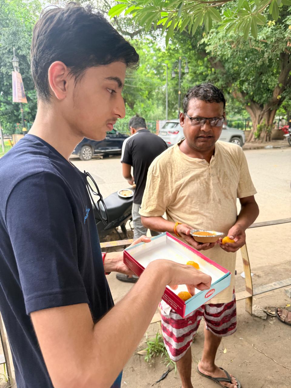 Jinanssh Jain sharing food with a community member during Nourish All.