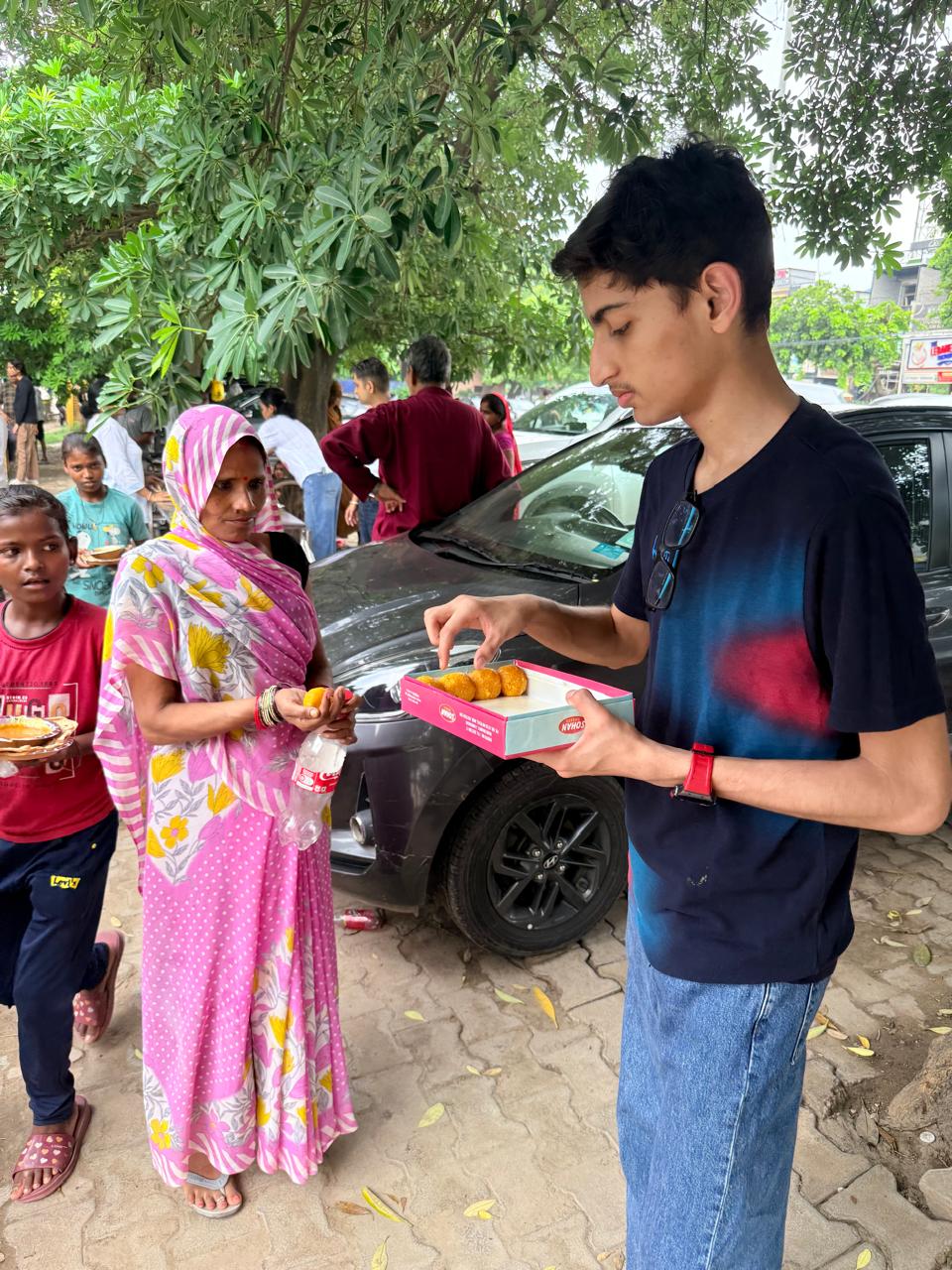 Jinanssh Jain sharing sweets with a woman during Nourish All on 4 August 2026.