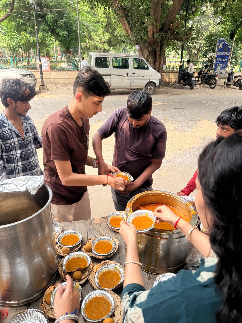 Jinanssh Jain serving a meal while plates are prepared during Nourish All.